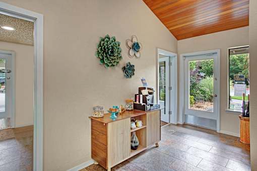 A room with a wooden cabinet and a green plant on the wall.