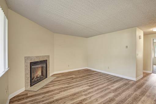 A room with a fireplace and wood flooring.