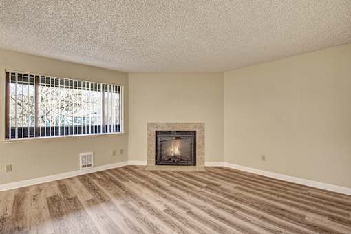 A room with a fireplace and a window with blinds.