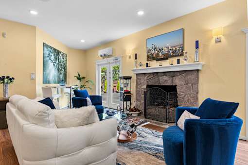 A living room with a fireplace and a painting on the wall.