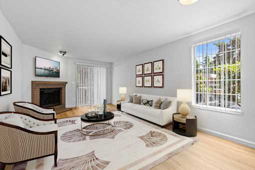A living room with a fireplace, couch, and pictures on the wall.