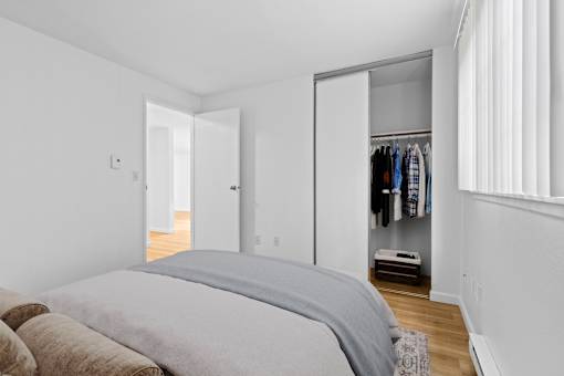A bedroom with a bed, a wardrobe and a window.