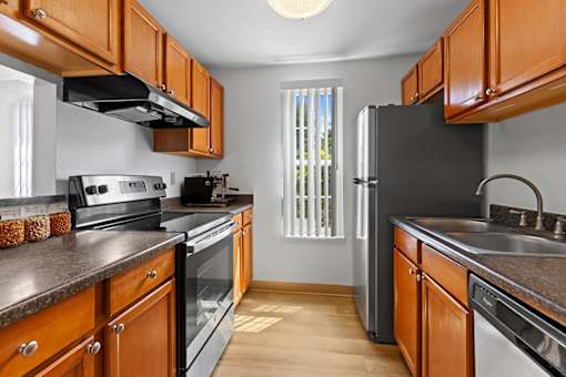 A kitchen with wooden cabinets and black appliances.