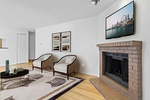 A living room with a fireplace and a television on the wall.