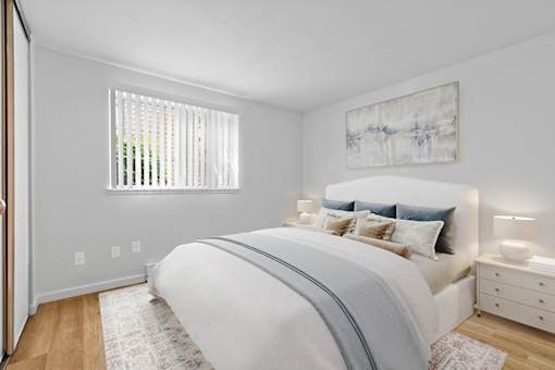 A bedroom with a large bed and a painting on the wall.