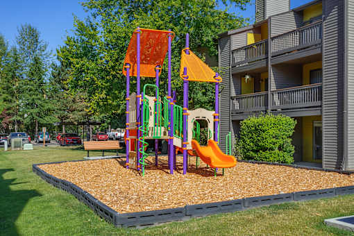A playground with a slide and a swing set.