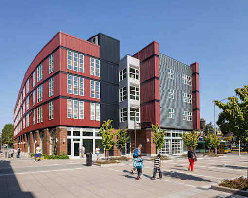 a red and gray building with people walking in front of it