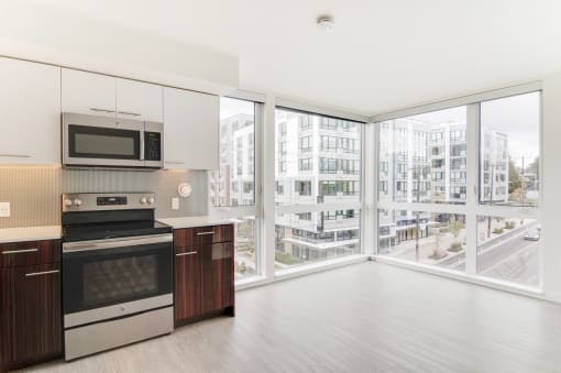a kitchen with a large window and a stove and a microwave
