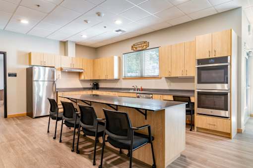 A kitchen with a refrigerator, oven, and sink.