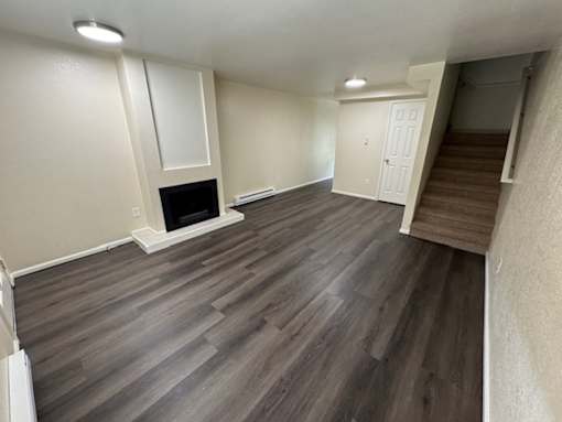 A room with a fireplace and wooden flooring.