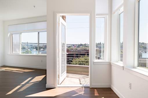 A room with a view of a bridge through the window.