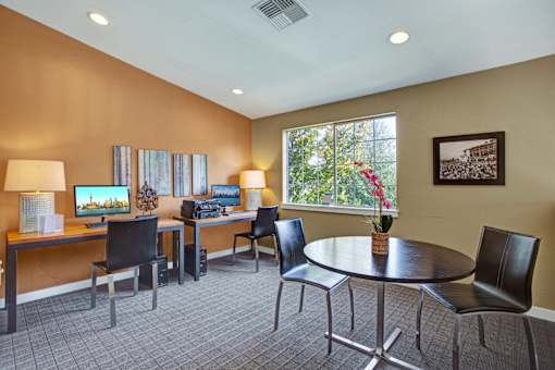 A conference room with a table, chairs, and a vase of flowers.