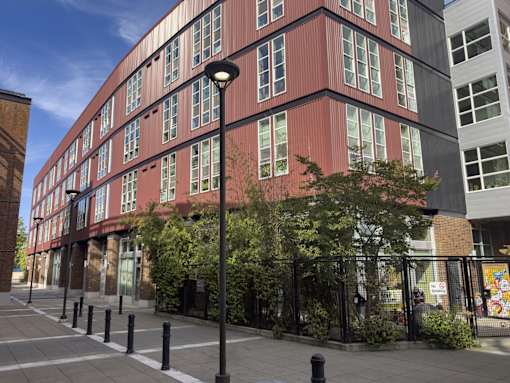 A red building with a black fence in front of it.