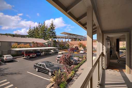 A parking lot with cars and a building in the background.