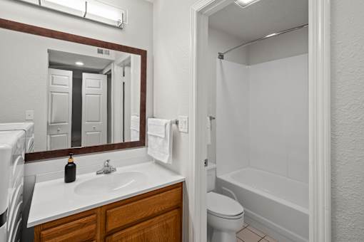 A bathroom with a white sink and a white toilet.