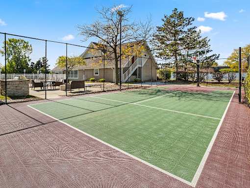 A tennis court with a green surface and a red surface.