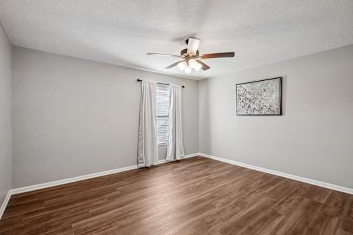 A room with a ceiling fan and a picture on the wall.