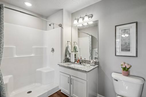 A white bathroom with a tub, sink, and toilet.