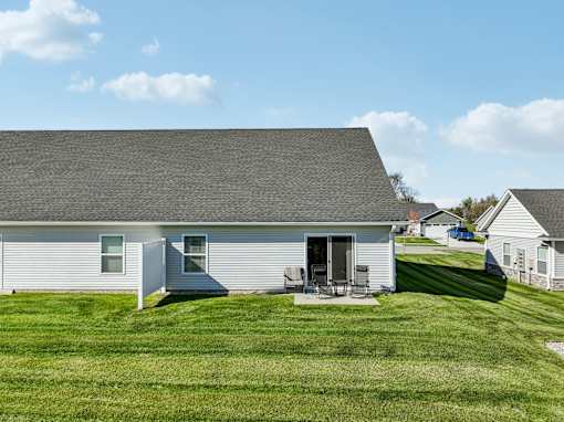 A house with a grey roof and a white garage door.
