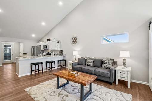 A living room with a grey couch and a wooden coffee table.