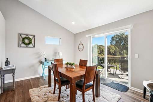 A dining room with a wooden table and chairs.