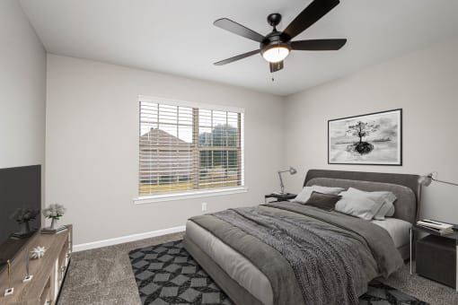 a bedroom with a bed and a ceiling fan