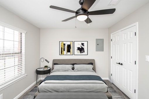 a bedroom with a bed and a ceiling fan