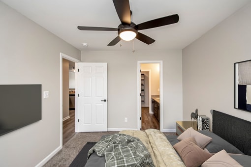a bedroom with a bed and a ceiling fan