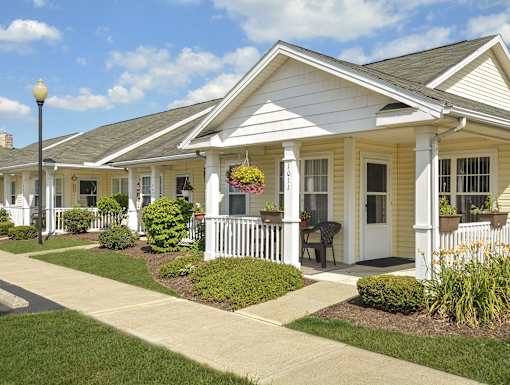 A white house with a porch and a white picket fence.