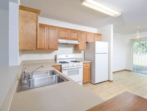 A kitchen with wooden cabinets and a stainless steel sink.