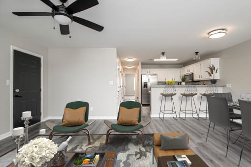 a living room and kitchen with a couch and chairs