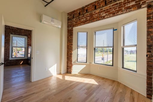 an empty living room with windows and a wood floor