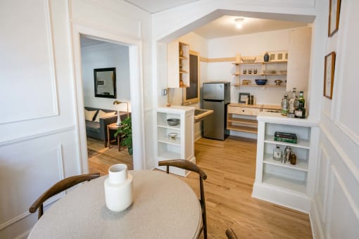 a view of a living room and a kitchen from a dining room table
