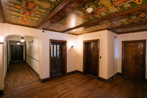 a large room with two doors and a mural on the ceiling