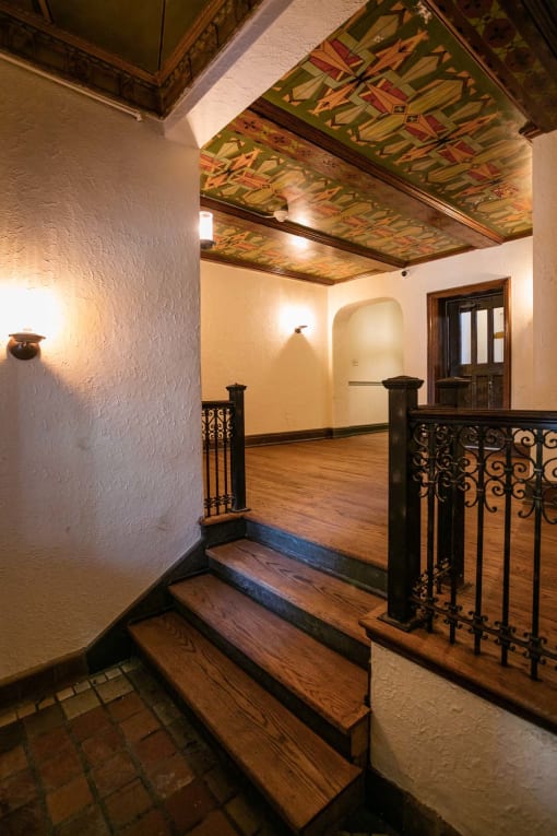 a lobby with stairs and a painted ceiling