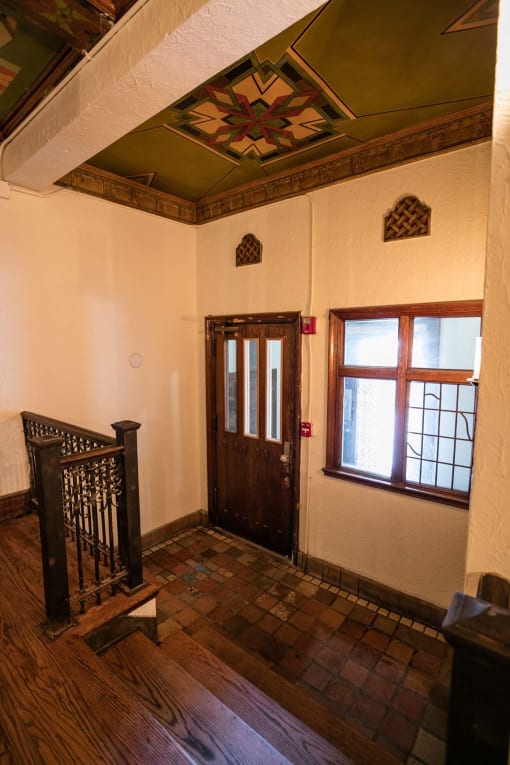 the entrance to a room with a wooden staircase and a window