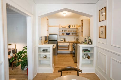 a view of a kitchen and a living room from a hallway