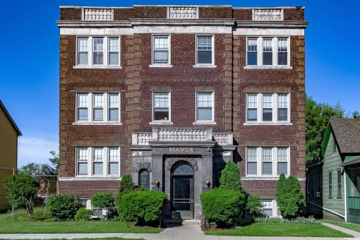 the front of a brick building with a sidewalk in front of it