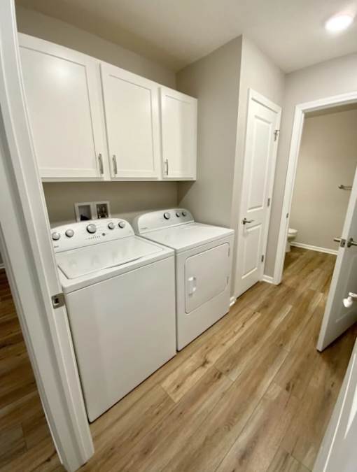 A laundry room with a washer and dryer built into the cabinetry.
