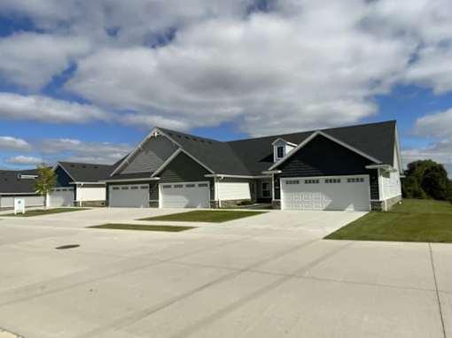 A large house with a grey roof and a white garage door.
