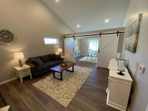A living room with a brown couch and a rug.
