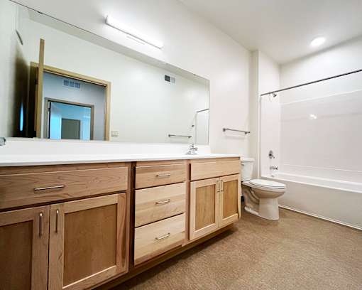 A bathroom with a toilet, sink, and mirror.