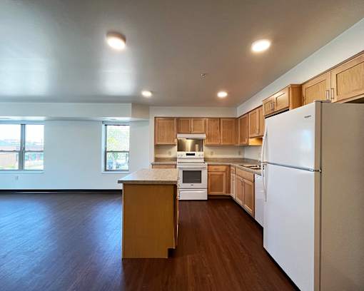 A kitchen with wooden cabinets and a white refrigerator.