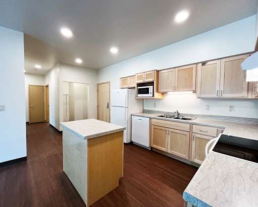 A kitchen with wooden cabinets and a white dishwasher.