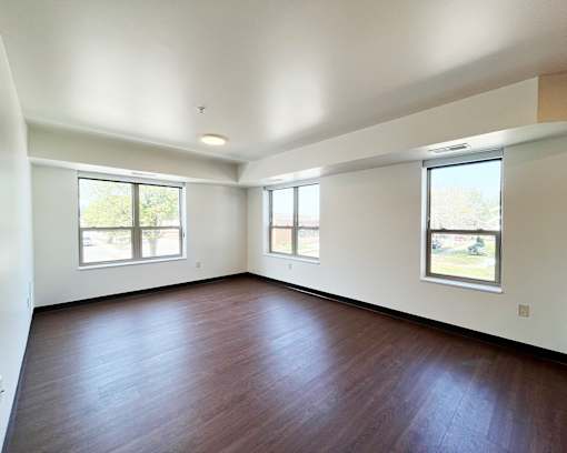 Empty room with wooden floors and white walls.