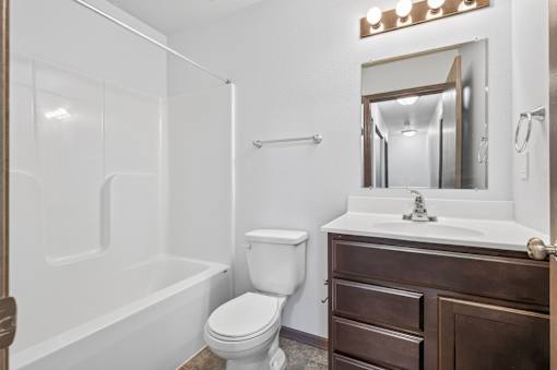 A white bathroom with a toilet, sink, and bathtub.