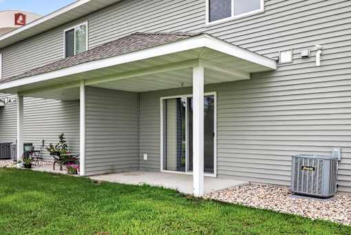 A house with a grey siding and a covered patio area.