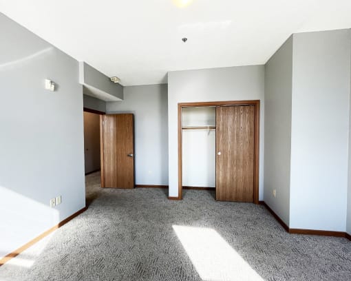 an empty living room with a door to a closet