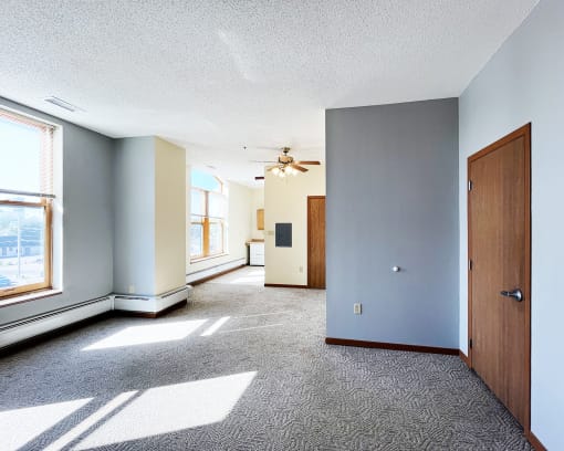 an empty room with a door and a ceiling fan