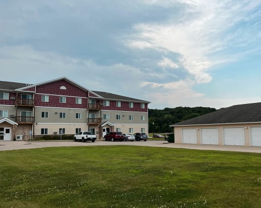 an apartment building with a green lawn in front of it